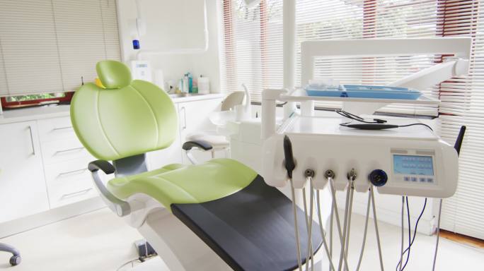 牙科诊所的室内空荡荡，配有绿色的牙科椅和工具