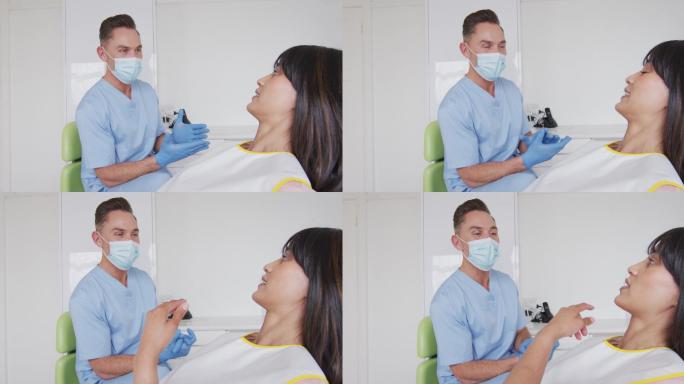 在现代牙科诊所，白人男性牙医带着面具为微笑的女性病人做准备