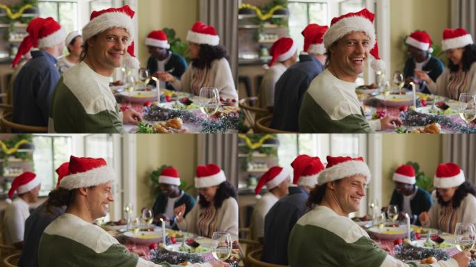 快乐的白人男子在圣诞期间与朋友庆祝晚餐