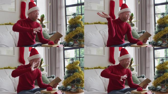 快乐的白化病非裔美国人戴着圣诞老人帽在圣诞节进行视频通话