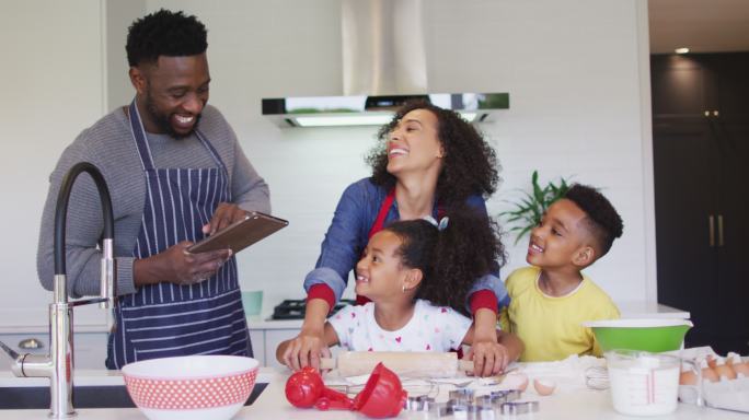 快乐的非裔美国家庭在厨房一起烘焙