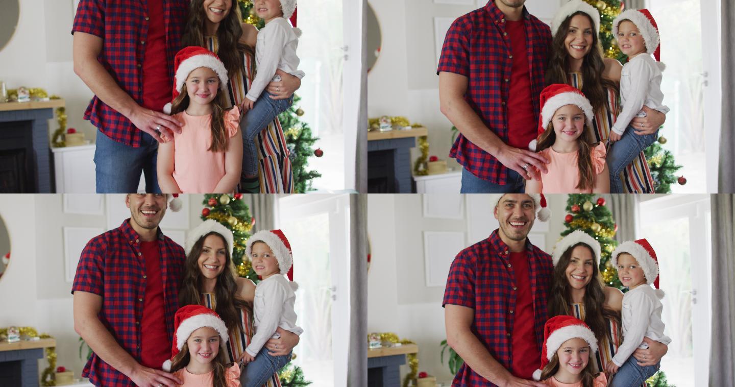 幸福的白人家庭戴着圣诞帽看着镜头