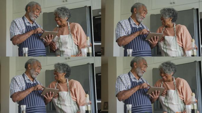 快乐的非裔美国老年夫妇一起烹饪，用平板电脑