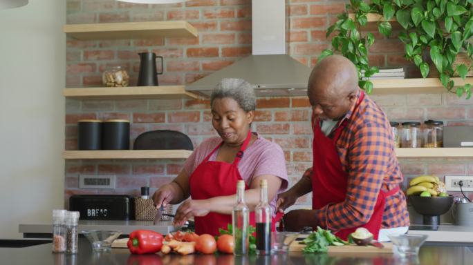 快乐的非裔美国老夫妇在厨房一起做饭
