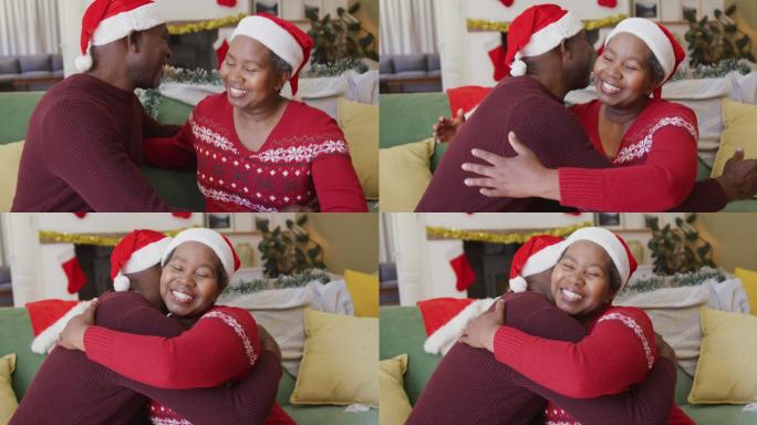 一对快乐的非洲裔美国老人戴着圣诞帽在客厅拥抱