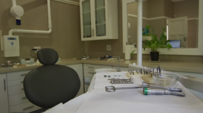 空荡荡的牙科诊所内部有黑色的牙科椅和工具