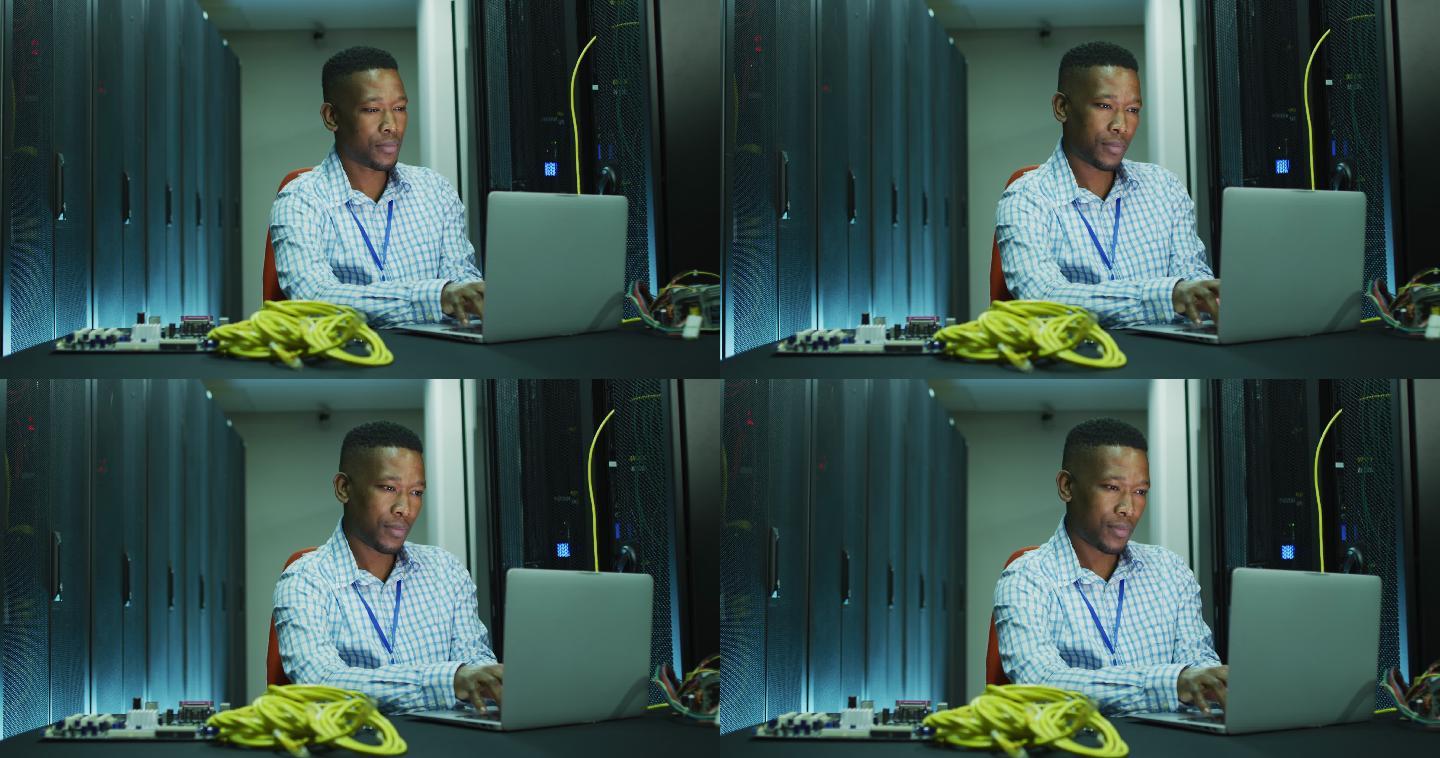 非裔美国男性电脑技术人员笔记本电脑在商业服务器室工作