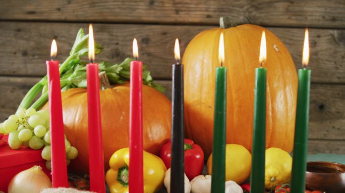 由七支点燃的蜡烛和万圣节南瓜和蔬菜组成