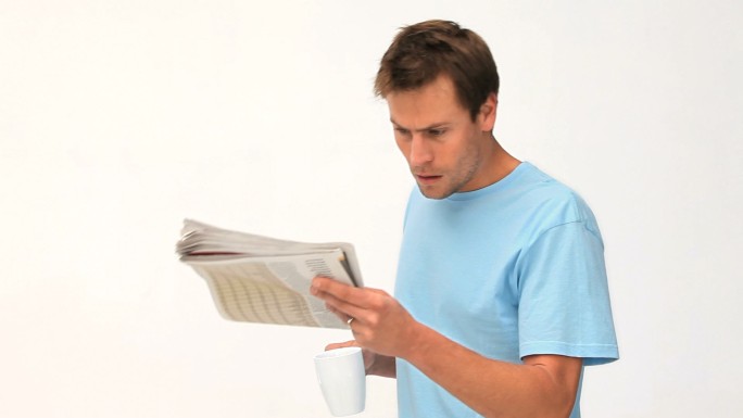 一名男子在喝咖啡看报纸特写