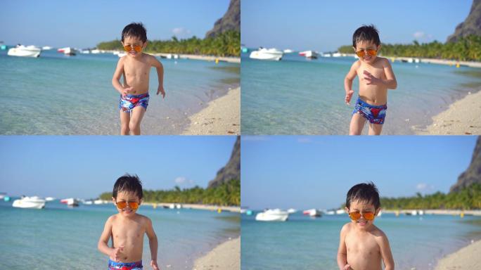 海边沙滩欢快奔跑的小男孩
