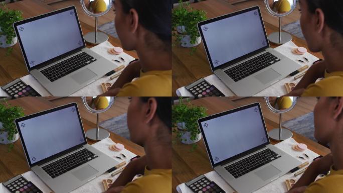 混合种族，性别，流动的人坐在办公桌前使用笔记本电脑在家工作