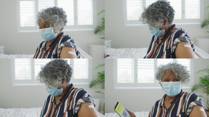 非裔美国老年妇女戴着口罩，出示防疫护照