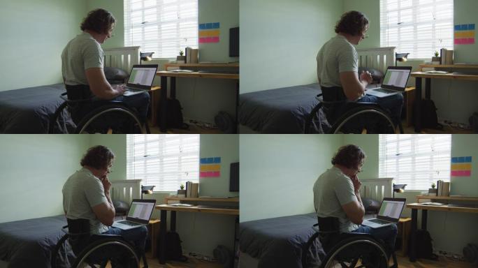 重点关注坐在轮椅上的白人残疾人在卧室里使用笔记本电脑