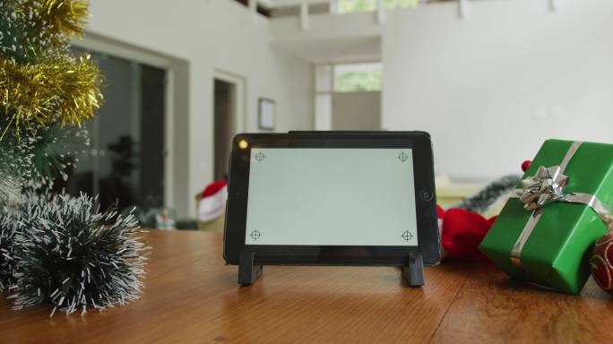 近距离的平板电脑与屏幕上的拷贝空间，在圣诞节坐在客厅的桌子上