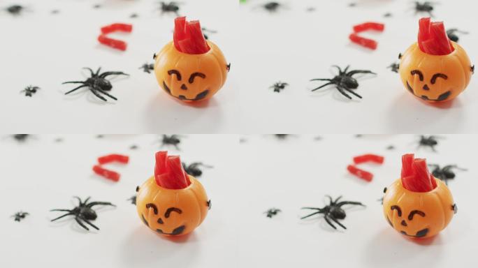 糖果在可怕的万圣节南瓜印桶和蜘蛛玩具的灰色背景