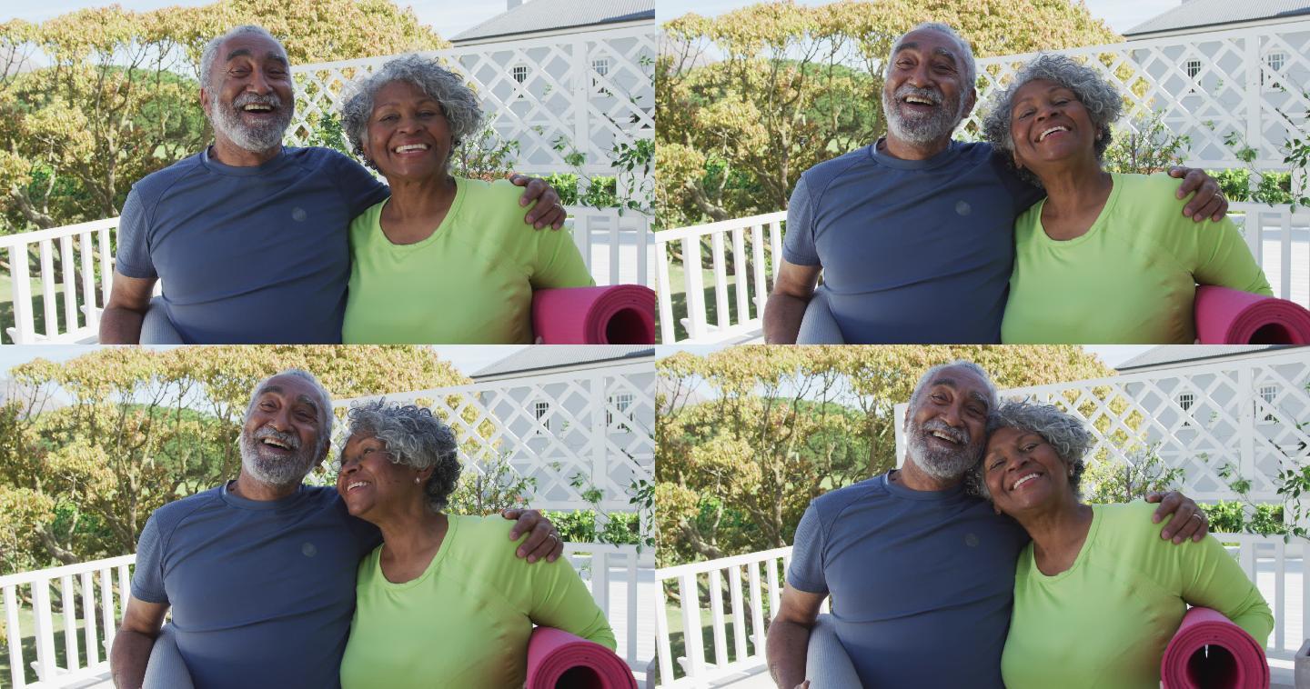 快乐的非裔美国老夫妇拿着瑜伽垫在露台上