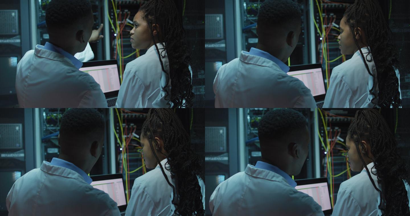 非裔美国人电脑技术人员使用平板电脑在企业服务器室工作