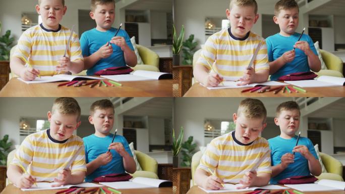 一个白人男孩和他的兄弟坐在桌子旁，在家里学习