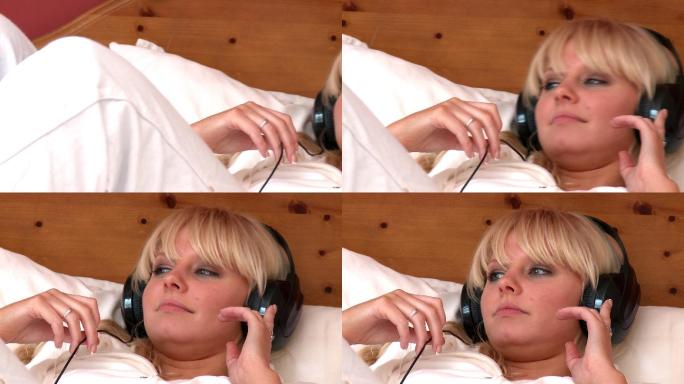 一个女人躺在床上听音乐特写