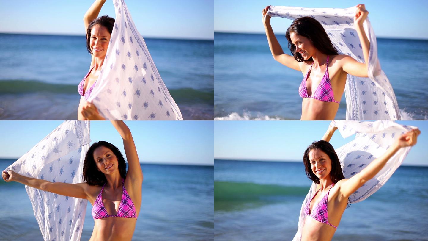 快乐的女人在沙滩上撩起她的纱笼