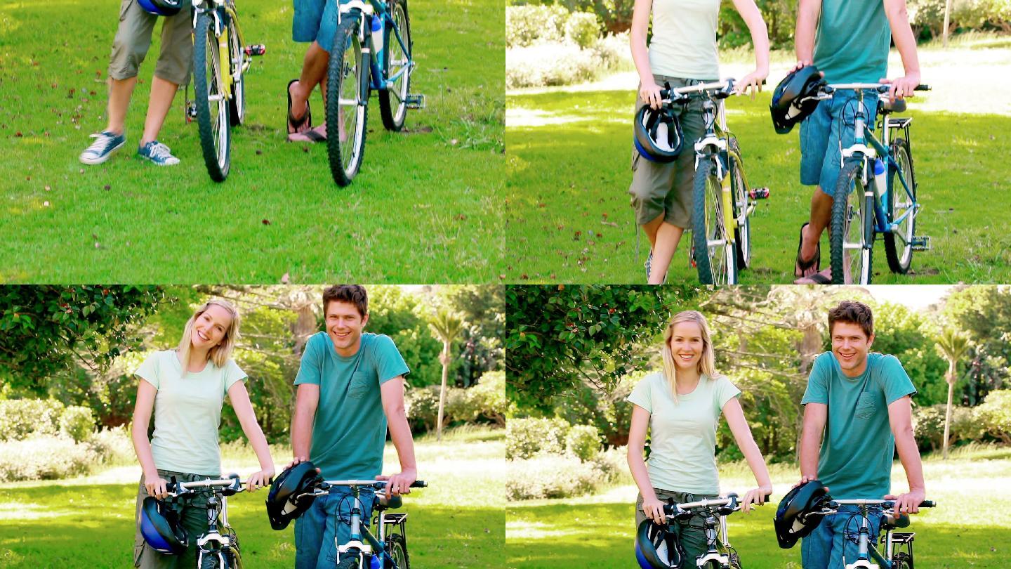 一对年轻夫妇骑着自行车站在公园里