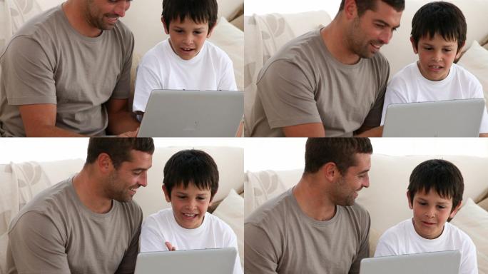父亲和儿子在沙发上玩电脑特写
