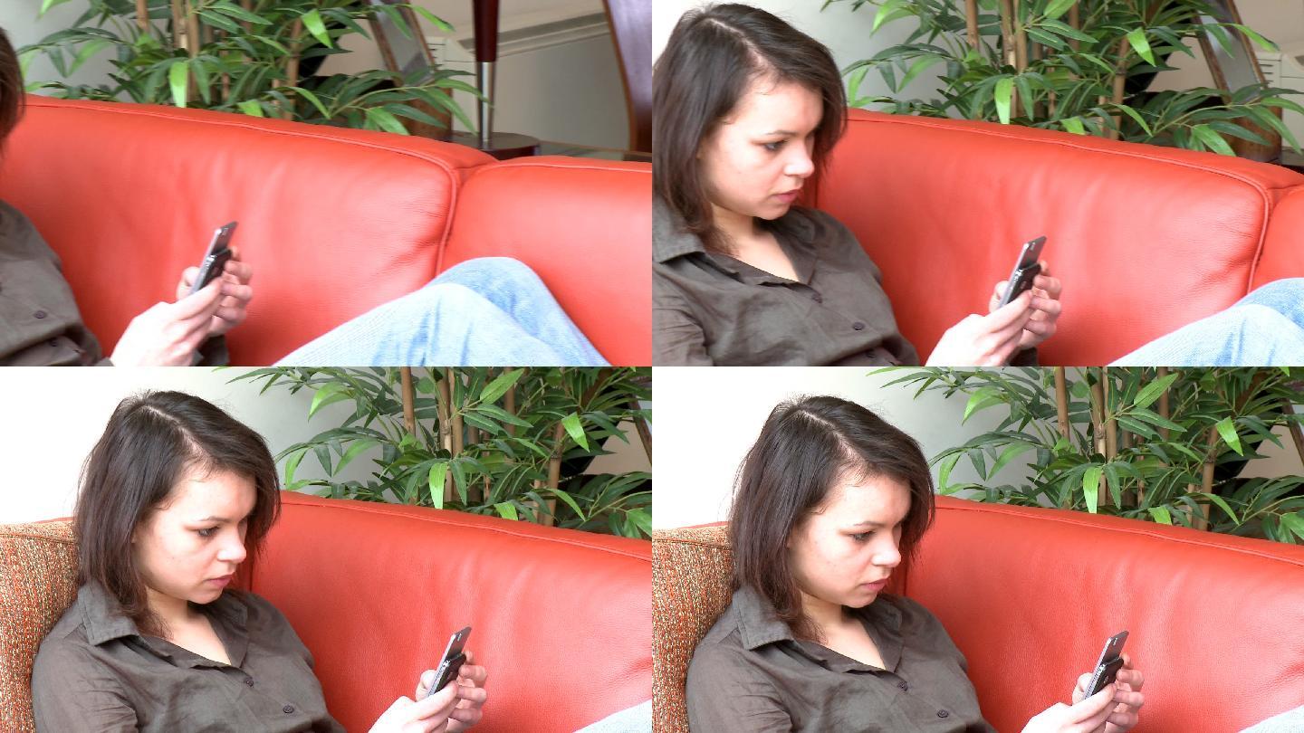 女人坐在沙发上发短信特写