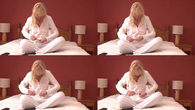 女人坐在床上测量腰围特写