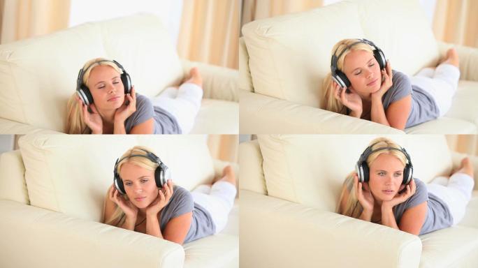 一个女人躺在沙发上听音乐特写