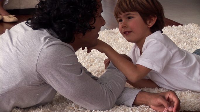 男孩和父亲在地毯上玩耍特写