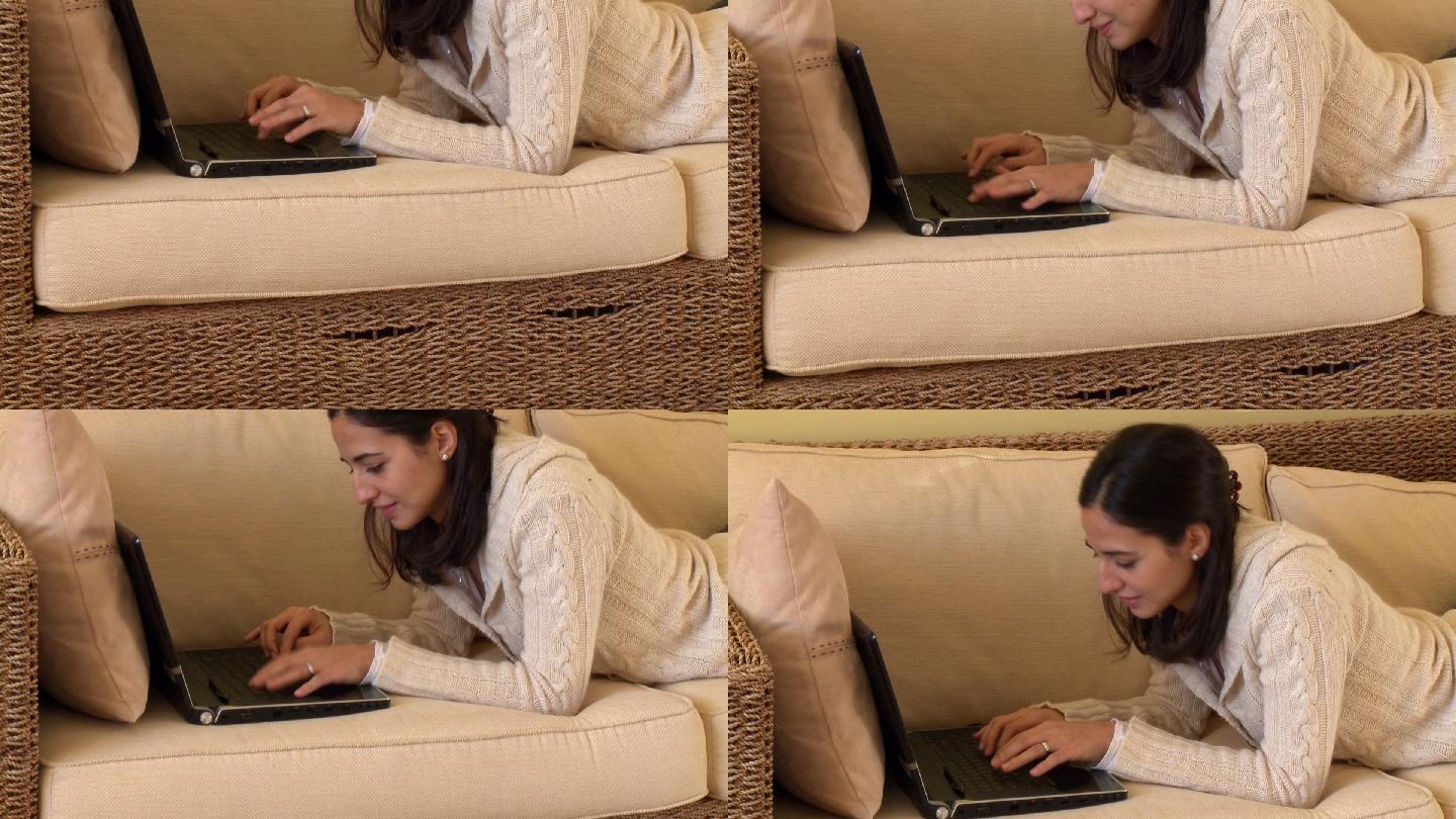 女人趴着沙发上玩电脑特写