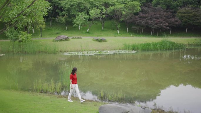 池塘边悠闲散步的女孩美女