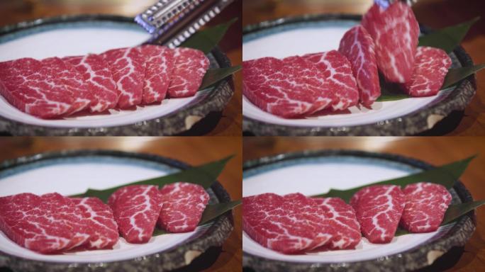 从盘中夹取牛肉