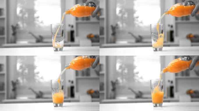 在黑白慢镜头中，一名男子用手将一瓶橙汁倒入玻璃杯中
