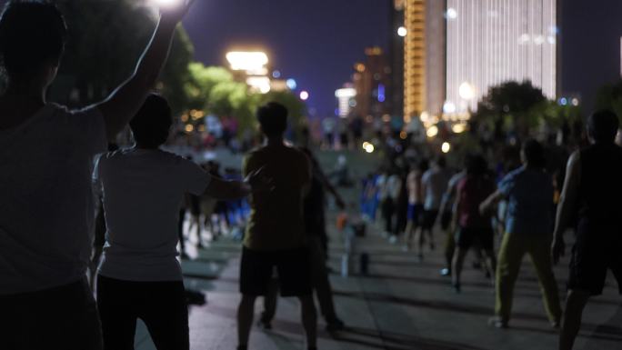 夏天夜晚江边跳广场舞的人群