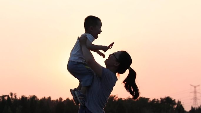 夕阳下妈妈孩子举高高成长陪伴童年快乐幸福