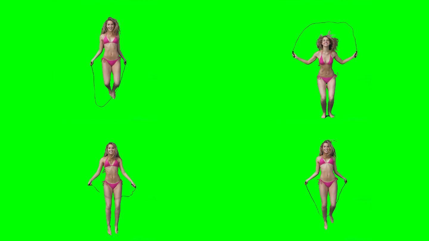 一个女人在绿色的屏幕上跳过绳子