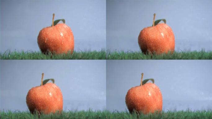 水落在红苹果上慢镜头，在蓝色背景下