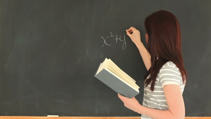 女人在黑板上写数学公式特写