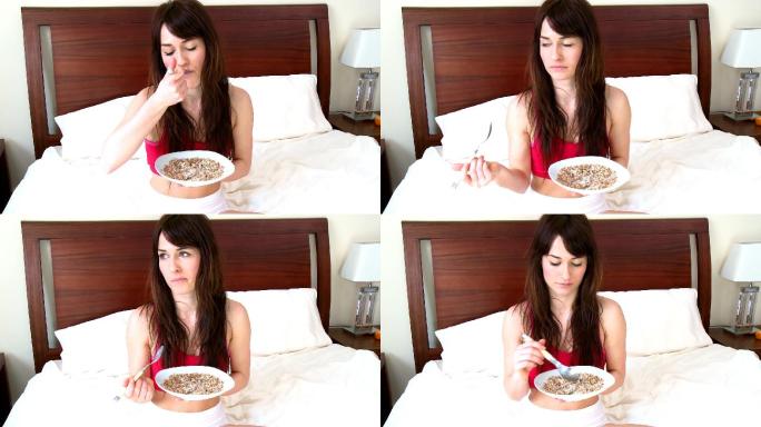 女人坐在床上吃早餐特写