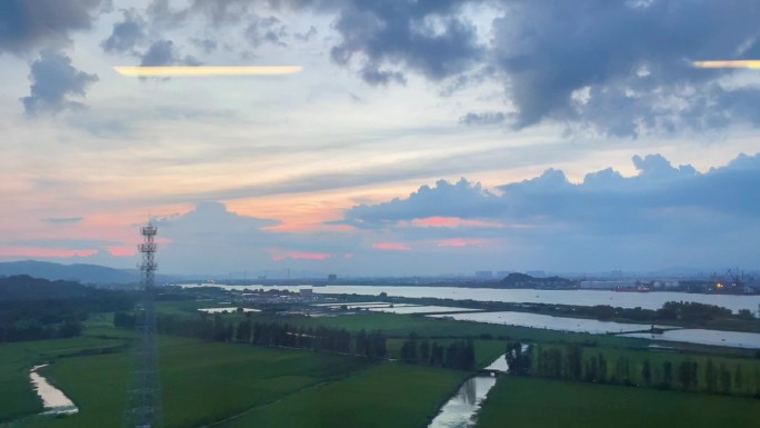 行驶中火车高铁傍晚窗外景色水稻农田江河