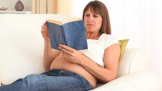 孕妇在沙发上读书特写