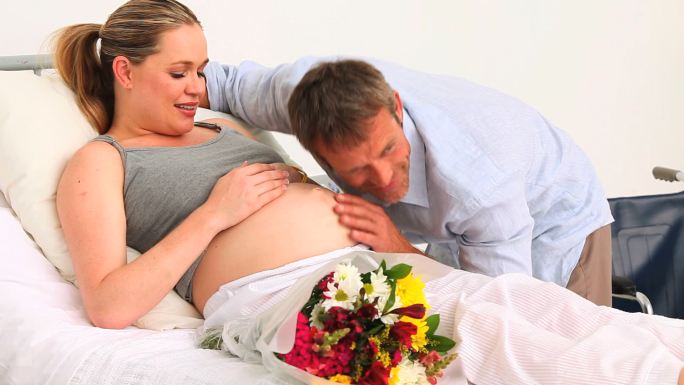 一名在诊所接受丈夫探访的孕妇