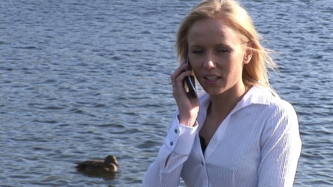 一个女人在河边打电话特写