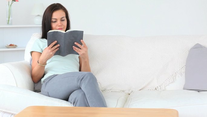 女人坐在沙发上看书特写