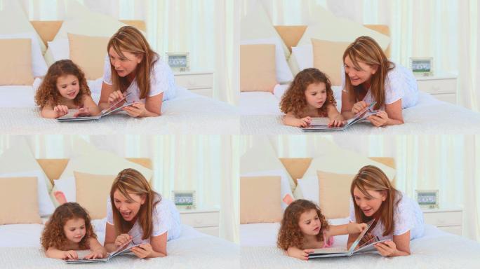 可爱的小女孩和她的奶奶在床上看书