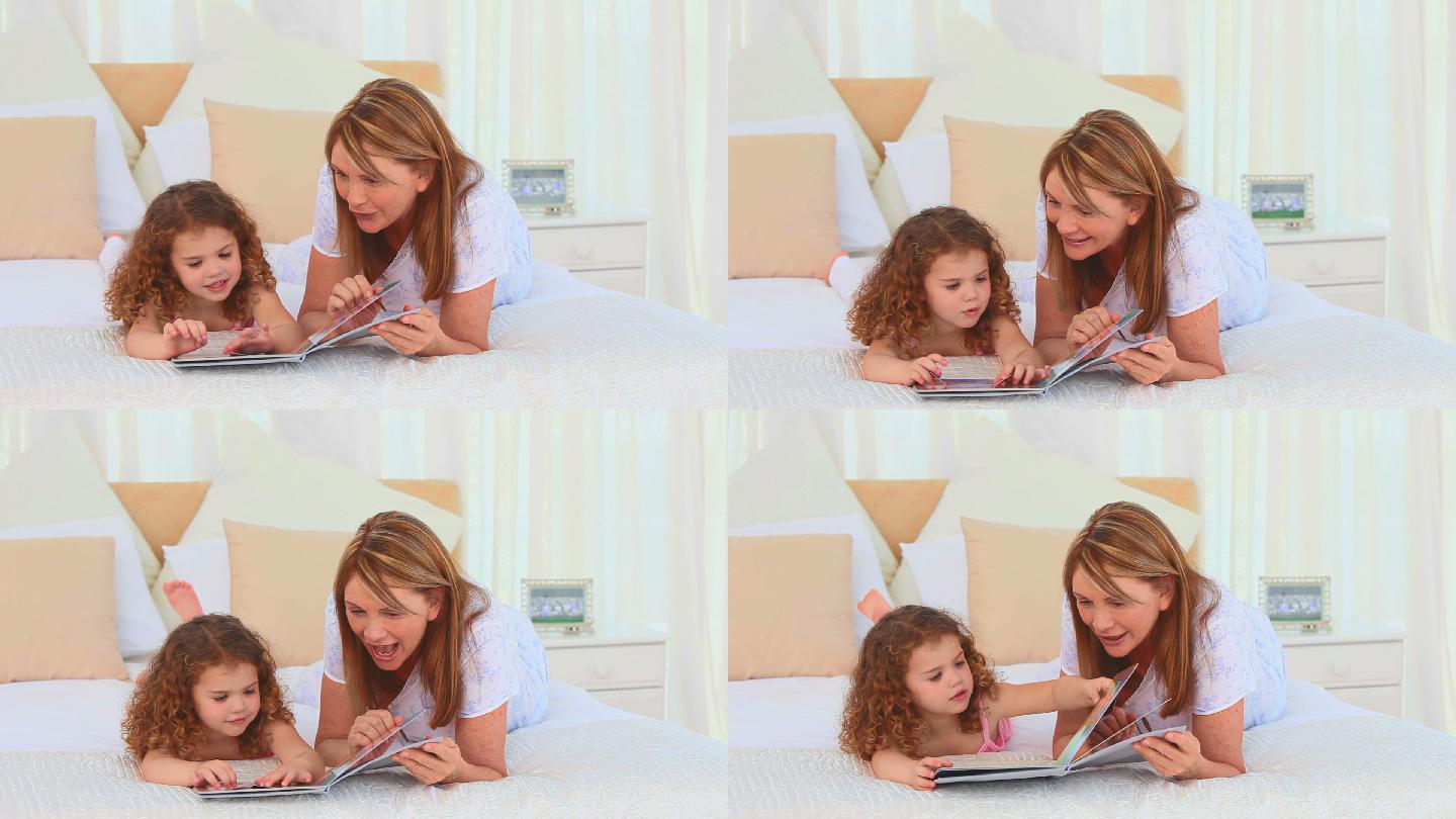 可爱的小女孩和她的奶奶在床上看书