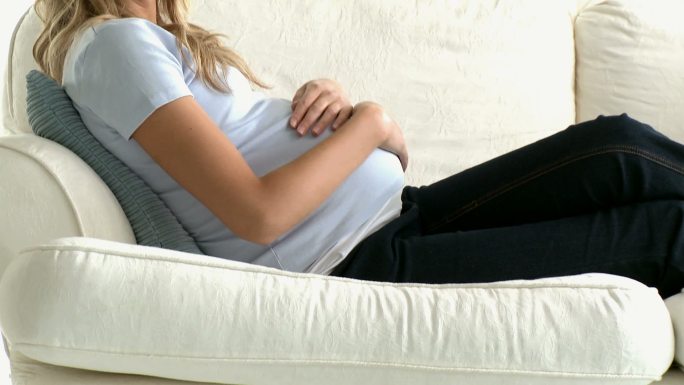 一个孕妇躺在沙发上特写