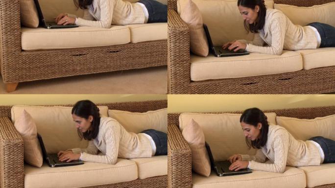 女人躺在沙发上看电脑特写