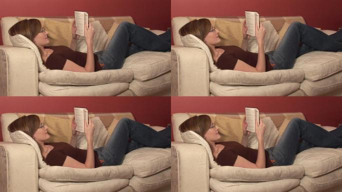 一个女人躺在沙发上读书特写